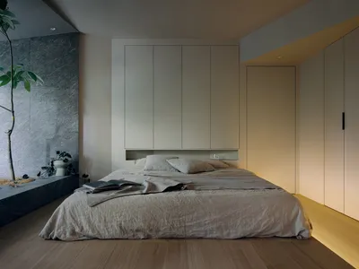 Minimalist bedroom with a wood floor, grey walls, and grey bedding.