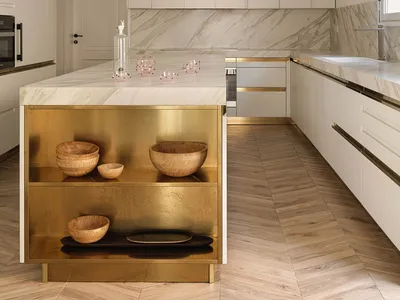 Contemporary kitchen featuring marble countertops and brass accents
