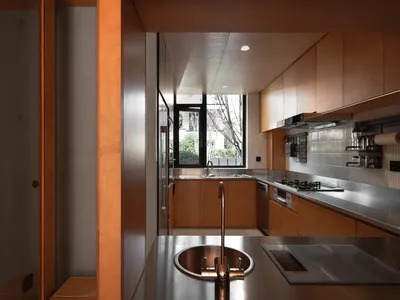 Modern kitchen with sleek countertops, stainless steel appliances, and contemporary wooden cabinetry.