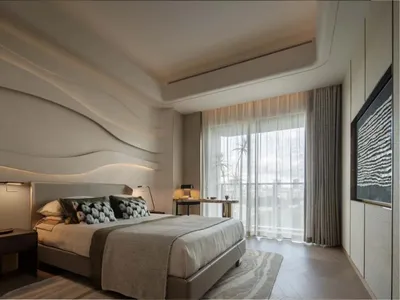Modern minimalist bedroom with a king-sized bed, wave-patterned headboard, and glass curtains allowing natural light to flood