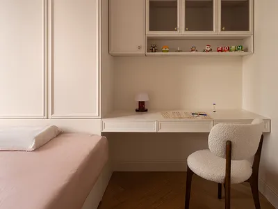 Minimalist bedroom with pink bedding and a wooden desk.