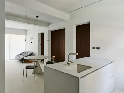 Modern minimalist kitchen with concrete countertops and a white island.