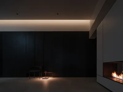 極簡客廳，採用混凝土地板與牆面，搭配溫馨壁爐與單人椅。