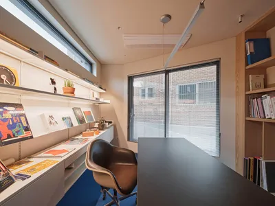 A modern home office featuring a sleek desk, comfortable chair, and organized shelves.