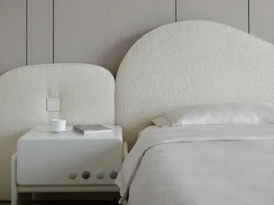 Minimalist bedroom featuring a bed with beige textured fabric headboard and bed frame, against a textured beige wall, with a