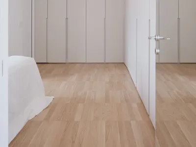 Minimalist bedroom with light-colored wooden flooring and simple, clean lines.