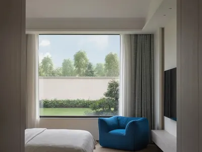 A modern minimalist bedroom with a wooden floor, a white bed, and a blue armchair, featuring a large window with a view of tr