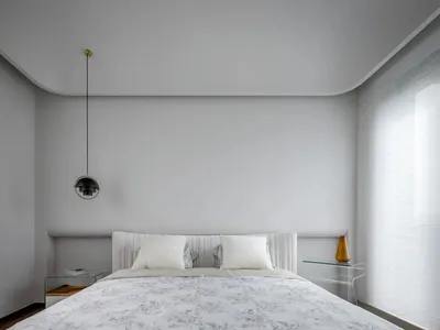 A minimalist modern bedroom with a light grey textured wall panel in the background and a white bed with floral bedding in th