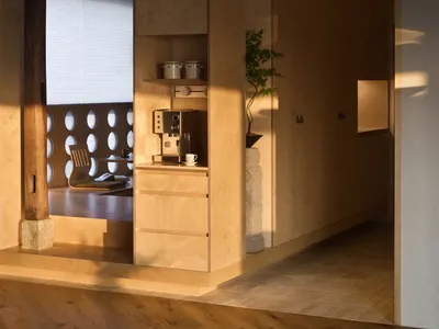 A modern kitchen with natural wood finishes and minimalist design features.