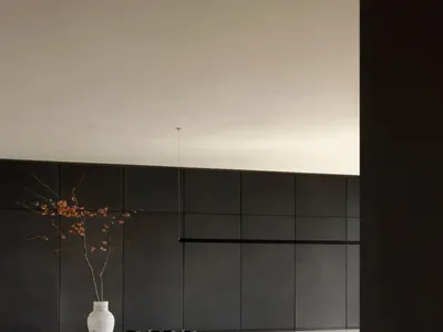 現代廚房配有黑色面板與木質餐桌。