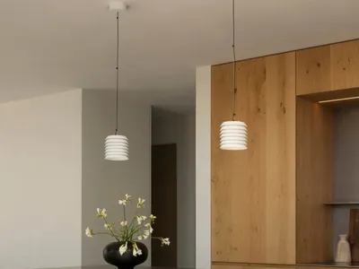 A modern minimalist kitchen featuring a concrete bar counter and wooden cabinets.