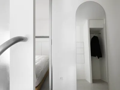 Minimalist bedroom interior with metallic accents and concrete floor.