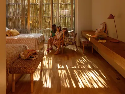 A modern bedroom featuring hardwood flooring and furniture with a minimalist design.