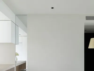 極簡客廳，採用混凝土地板、白色家具，以及帶有黑色重點的牆面。