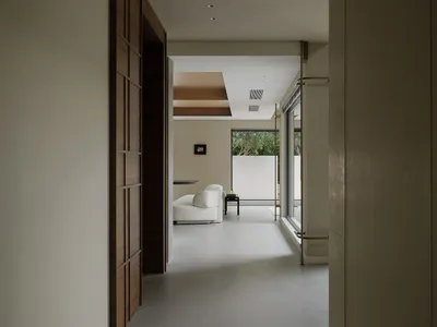 A minimalist living room featuring concrete walls and floor.