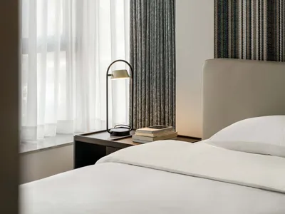 A modern bedroom featuring grey and white fabric curtains