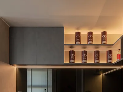 Modern, minimalist residential kitchen featuring concrete countertops and cabinets with ambient lighting.