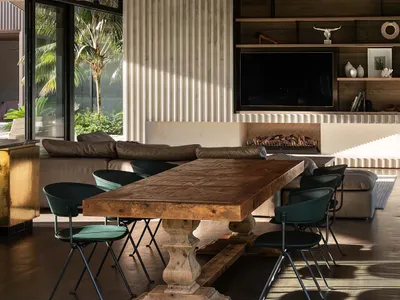 Modern industrial living room with wooden furniture and corrugated metal accent wall.