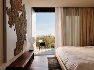 Minimalist bedroom with neutral tones and a view of nature.