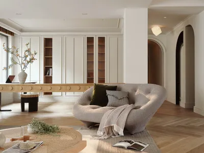 A modern living room with a Scandinavian design featuring a curved sofa, wooden coffee table, and bookcase.