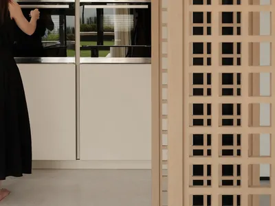 A modern, minimalist kitchen featuring sleek, light-colored cabinets with a clean, uncluttered design.