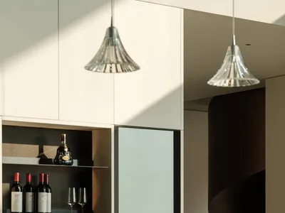 Modern kitchen with metallic finishes and wine rack with glasses.