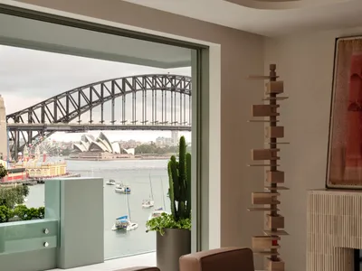 Contemporary living room with modern furniture, a cactus plant, and a view of the Sydney Opera House and Harbour Bridge acros
