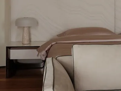 A minimalist bedroom featuring a beige upholstered bed with marble nightstand and beige fabric bedding.