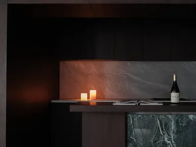 Modern kitchen design featuring sleek black cabinetry, marble countertops, and warm ambient lighting.