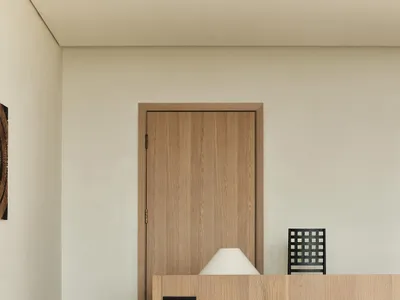 Minimalist bedroom featuring a wooden bed with a wooden headboard and white bedding.