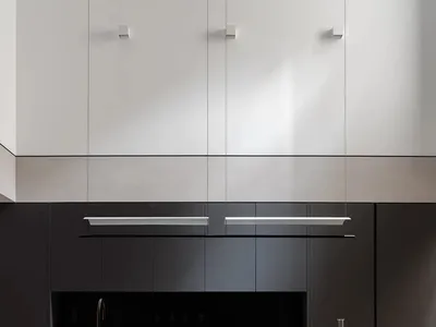 Modern minimalist kitchen with black stainless steel appliances and black countertops.