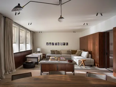 A minimalist Scandinavian living room with a white sofa, wood coffee table, and stone wall.