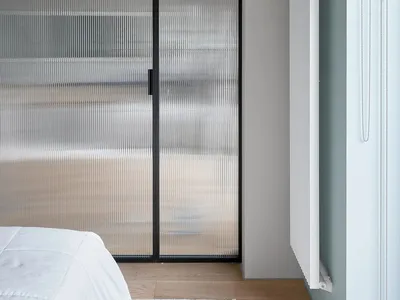 Minimalist bedroom featuring frosted glass panels and white radiator.