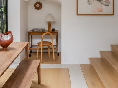 A modern home office space with white walls, wooden furniture, and a minimalist design.