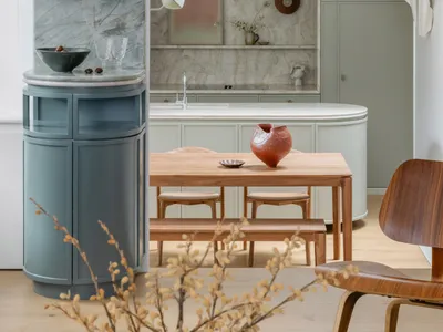 Modern living, dining, and kitchen space featuring marble countertops, wooden furniture, and ceramic ornaments.