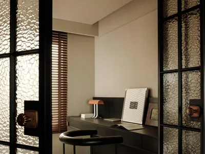 Minimalist home office with industrial design elements, featuring wooden furniture and a black chair.