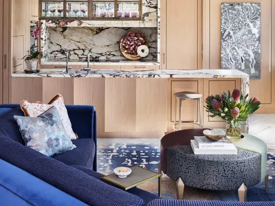 Modern living room kitchen with open concept, featuring marble, wood, and metal materials.
