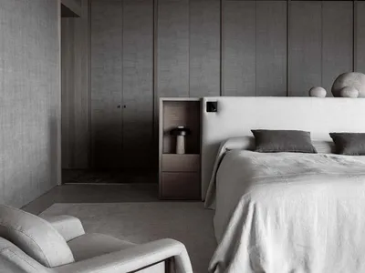 A modern, minimalist bedroom featuring metallic gray textures and a large bed with grey linens.