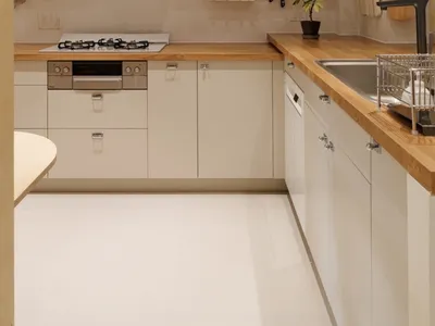 Modern, minimalist residential kitchen featuring wood and laminate surfaces.