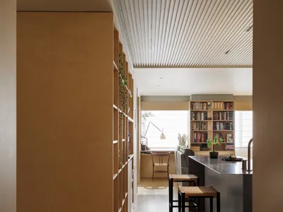 Minimalist modern kitchen featuring wooden cabinets and glass countertops, designed for efficiency and aesthetic appeal.