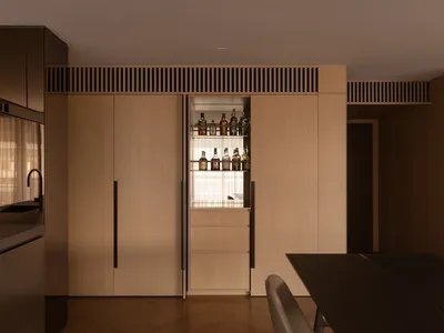 Contemporary minimalist kitchen featuring wooden cabinets and a built-in bar.