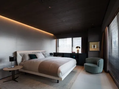 A minimalist bedroom featuring a fabric bed and modern furnishings.