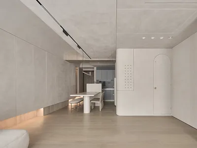 極簡風格的廚房，採用混凝土飾面，並設有中央餐桌。