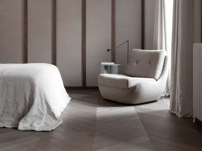 Minimalist bedroom featuring fabric furniture, wood flooring, and glass panels.