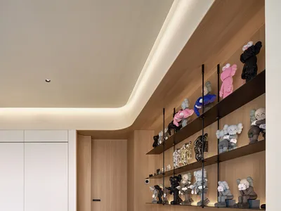 現代居家辦公室，木質層架上展示各種絨毛玩偶。