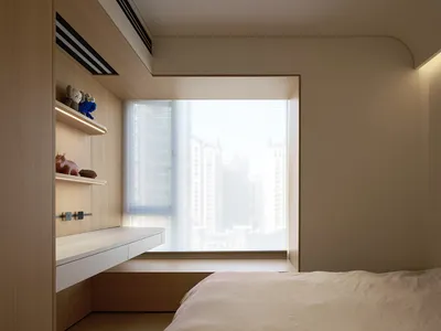 A serene, minimalist bedroom with a window overlooking a cityscape, featuring a wooden bed frame and sleek, white furnishings