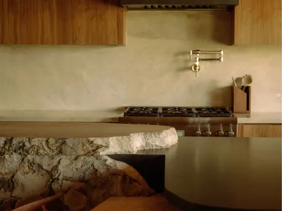 Modern kitchen with stone countertop and wooden cabinets.