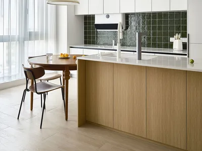 a modern residential kitchen featuring wooden cabinets and glass backsplash.