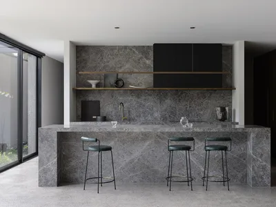 A modern kitchen with a marble countertop, bar stools, and dark cabinets.