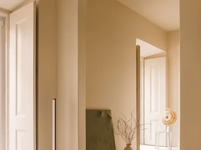 A serene minimalist bedroom featuring concrete walls, a natural rug, and minimal decor.